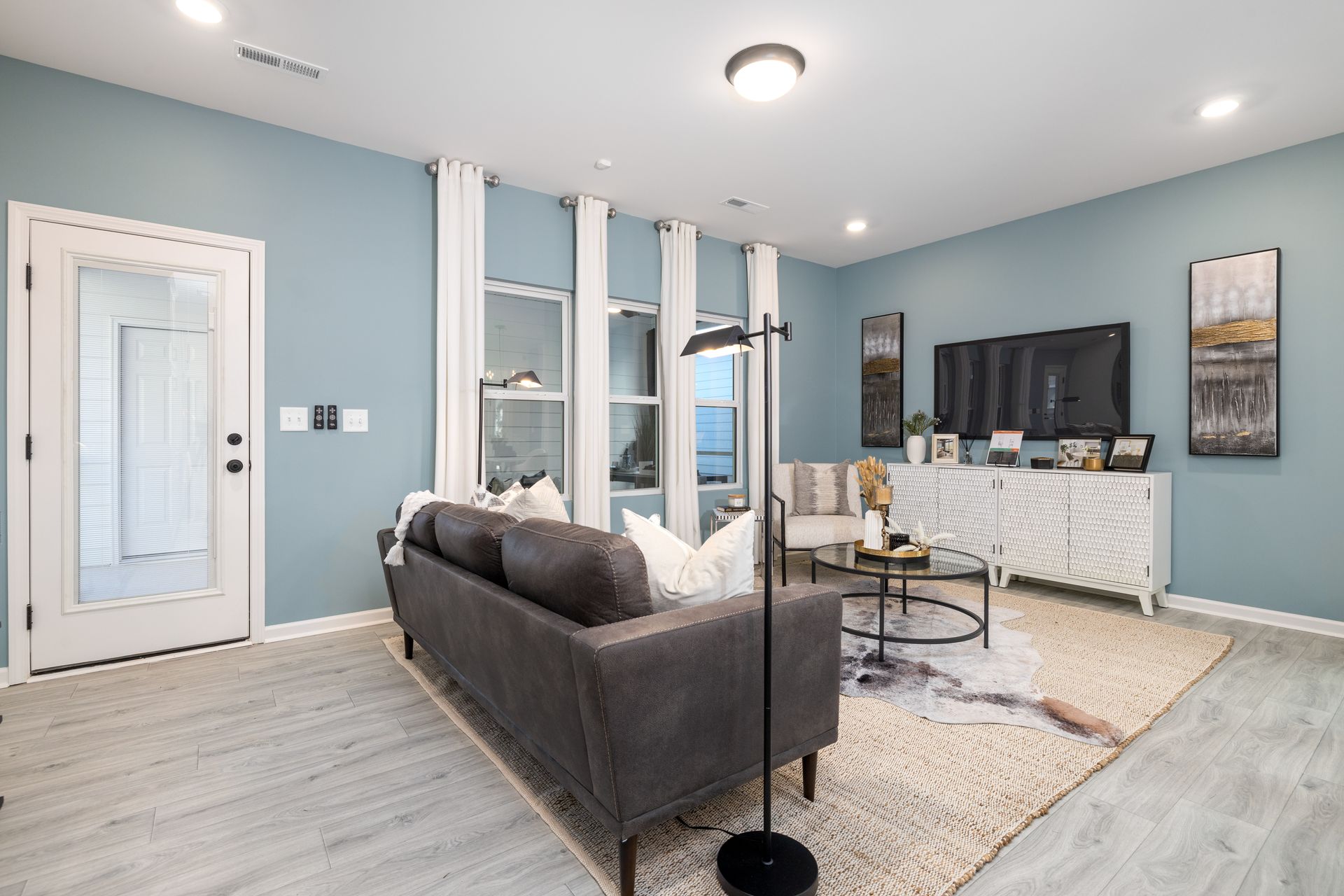 A living room with a couch , chair , table and television.