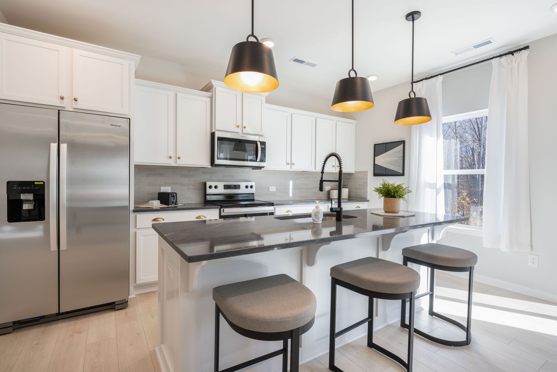 A kitchen with stainless steel appliances and white cabinets