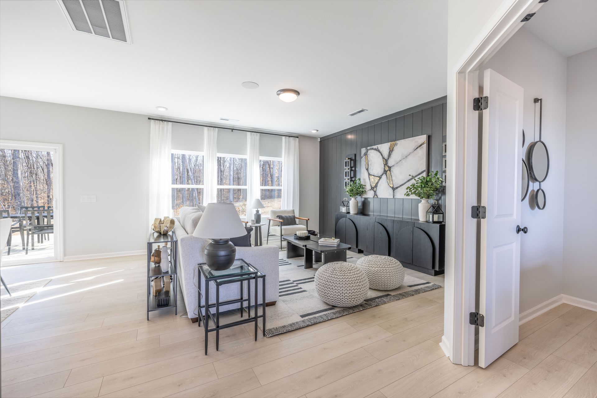 A living room with a couch , chair , table and lamp.