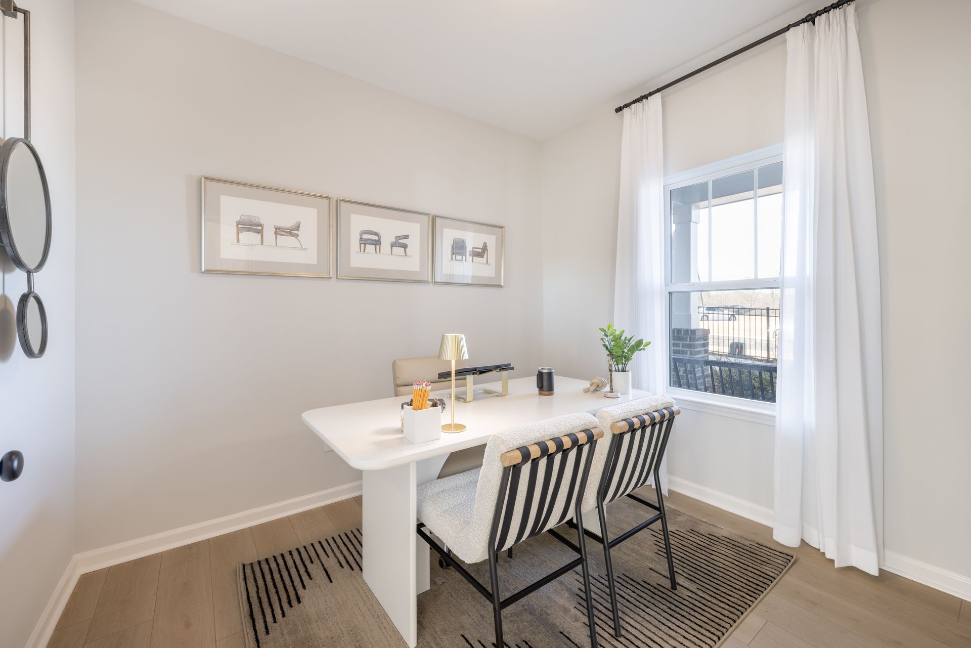 A dining room with a table and chairs and a window.