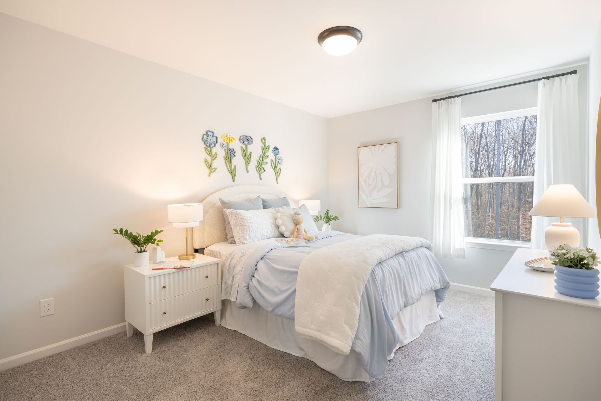 A bedroom with a bed , nightstand , dresser and window.