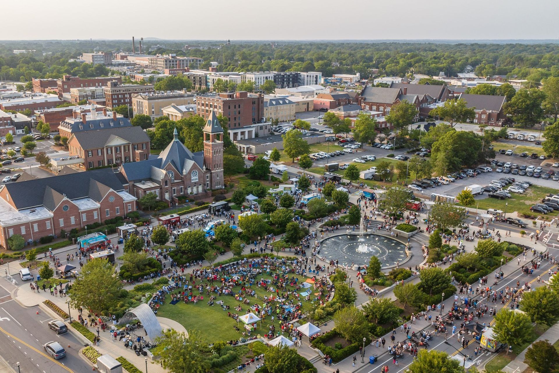 An aerial view of a city with a fountain in the middle of it.
