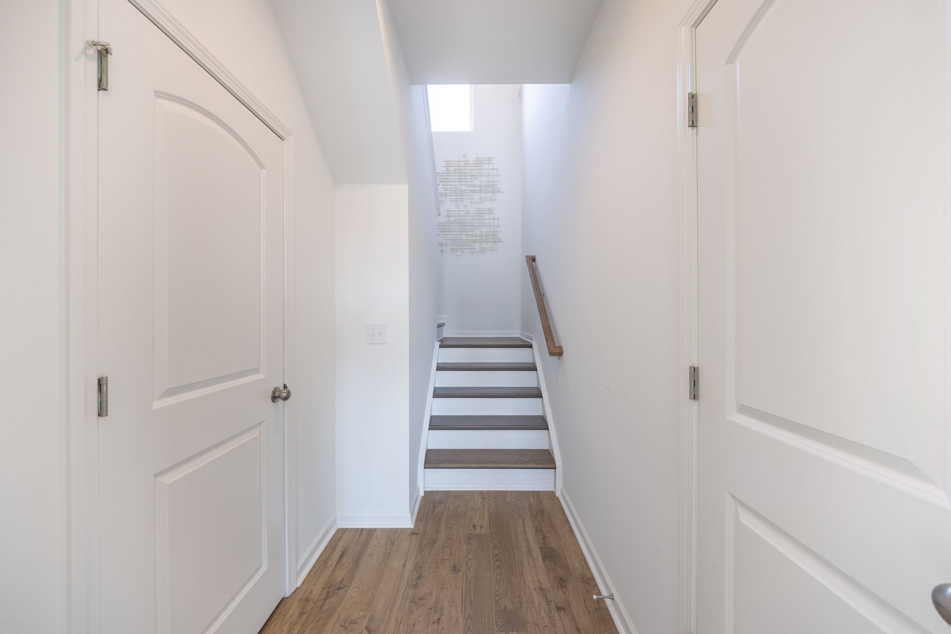 A hallway with stairs leading up to the second floor of a house.
