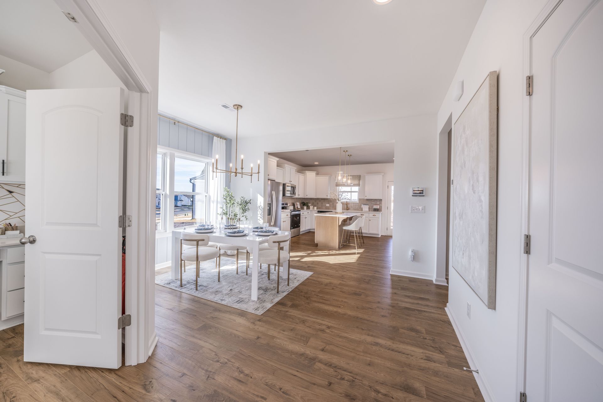A hallway leading to a kitchen and dining room in a house.