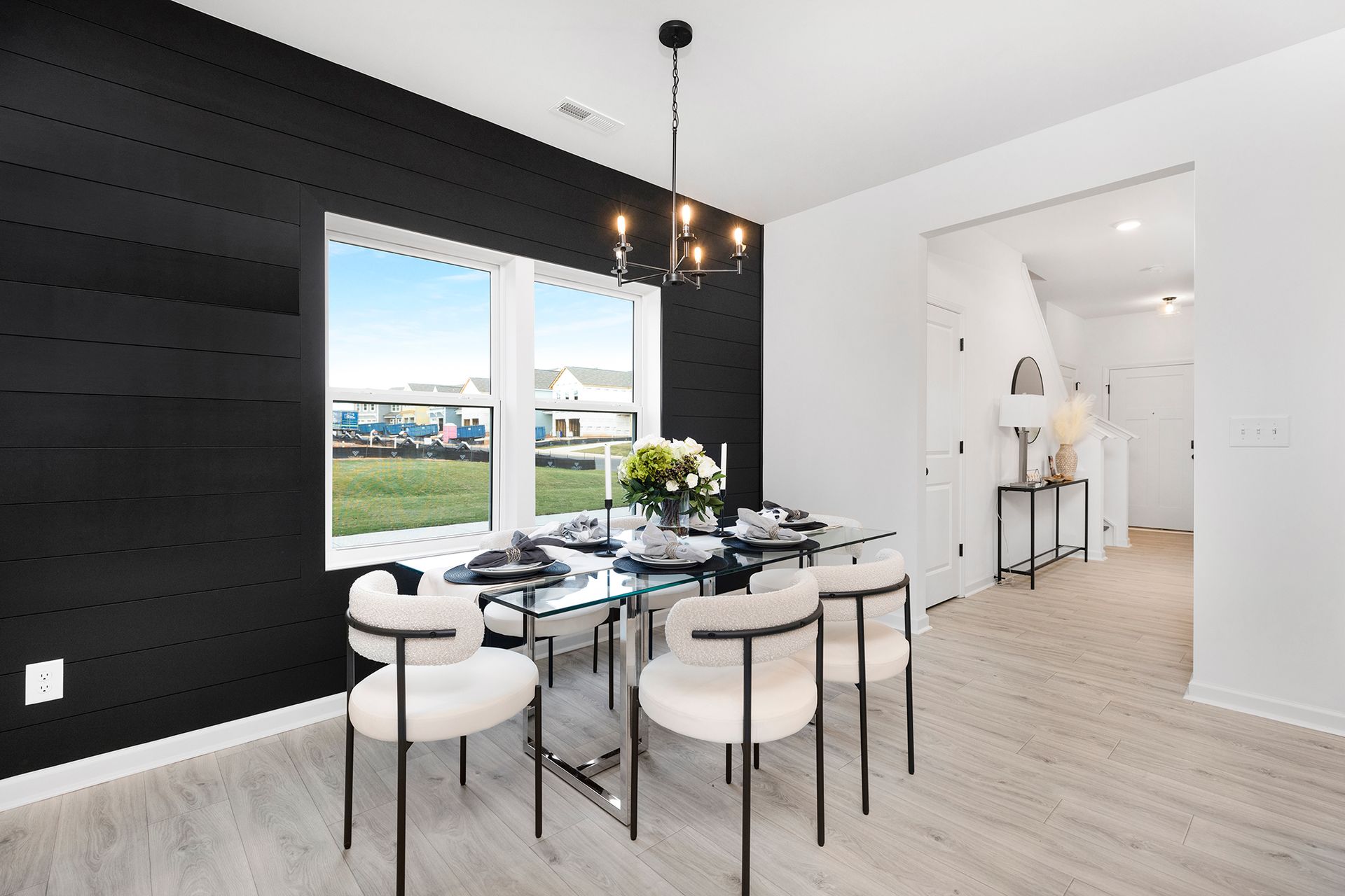 A dining room with a table and chairs and a black wall