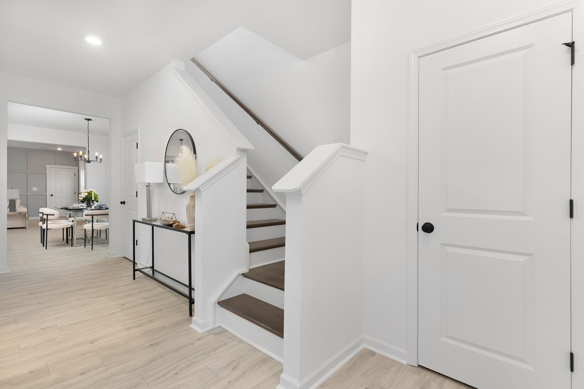 A hallway with stairs leading up to the second floor of a house.