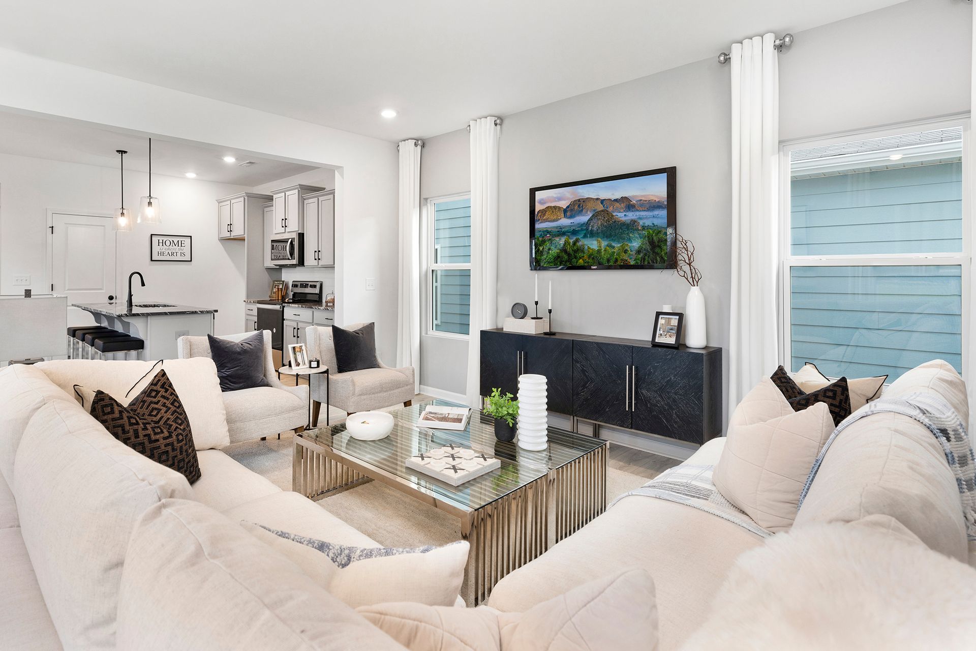 A living room with two couches , a coffee table , and a flat screen tv.