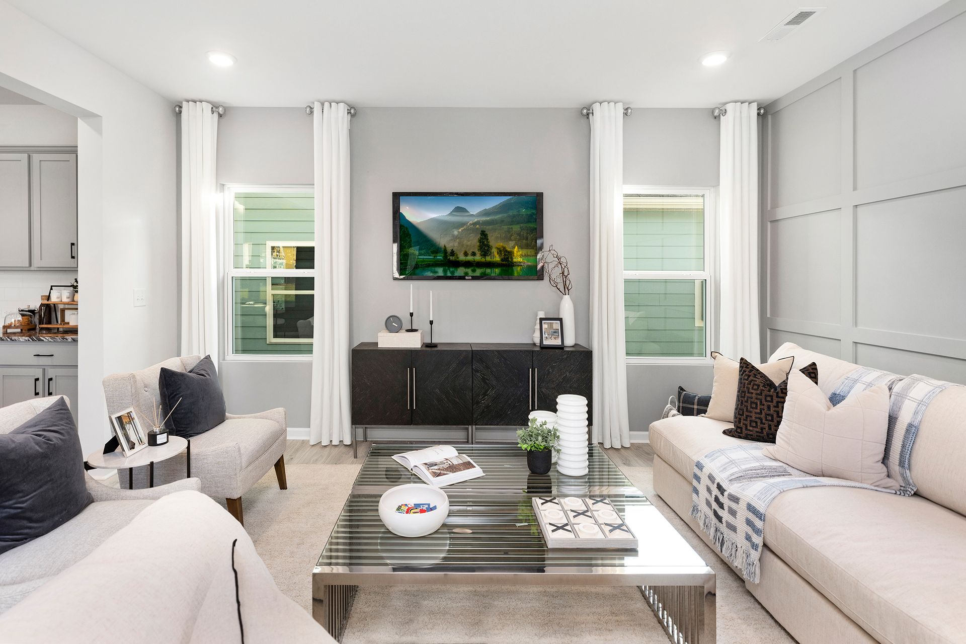 A living room with two couches , a coffee table , and a flat screen tv on the wall.