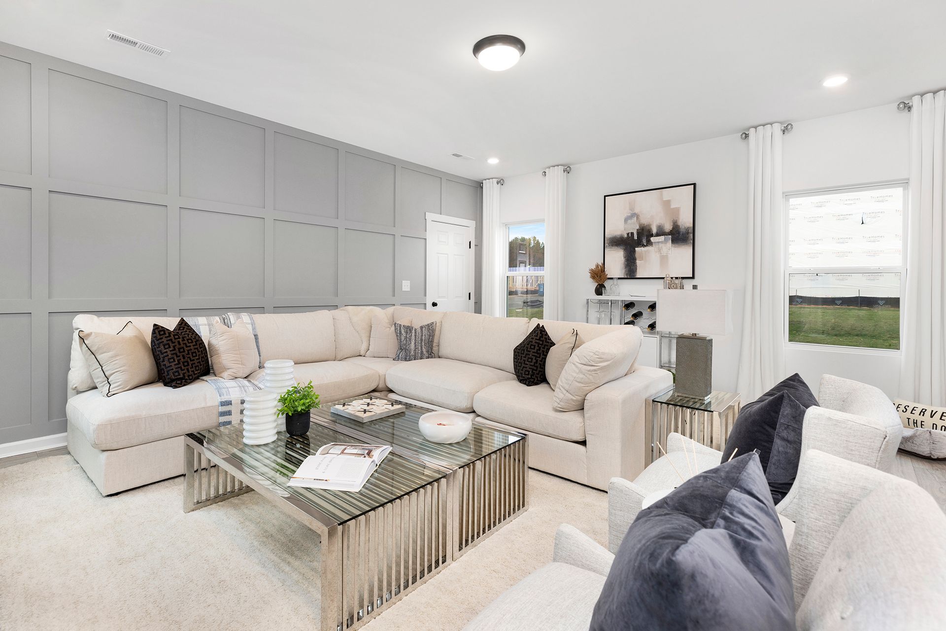 A living room with a large sectional couch and a glass coffee table.