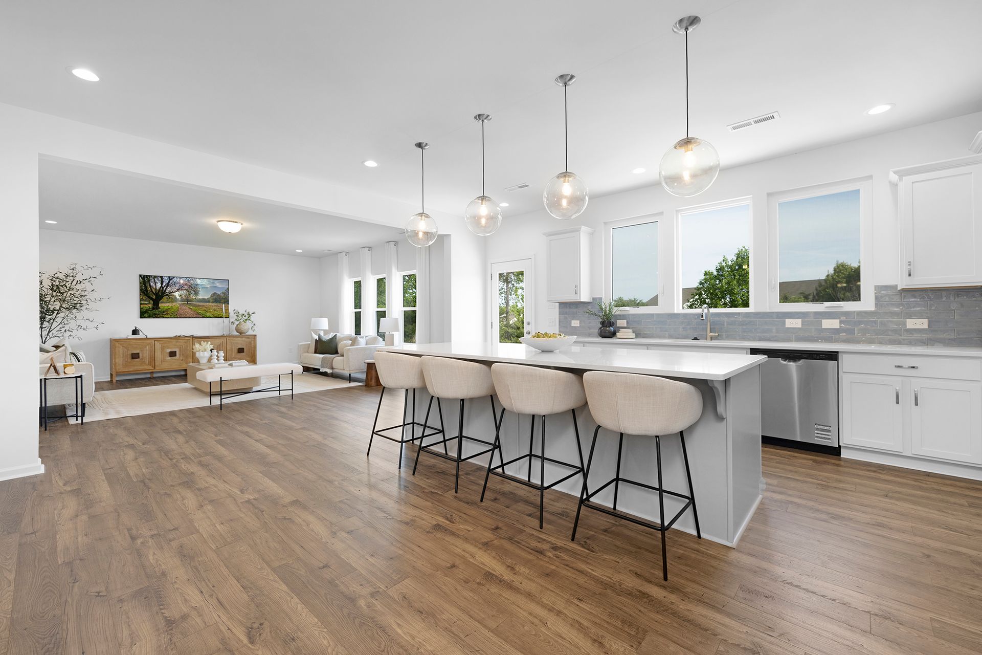 A kitchen with a large island and stools in a house.