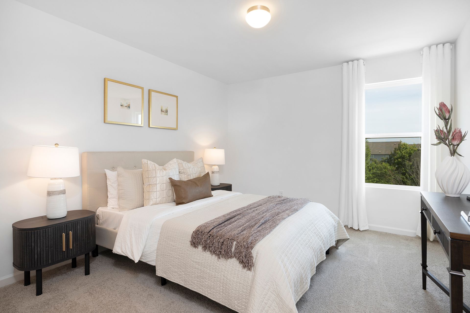 A bedroom with a bed , nightstands , lamps and a window.