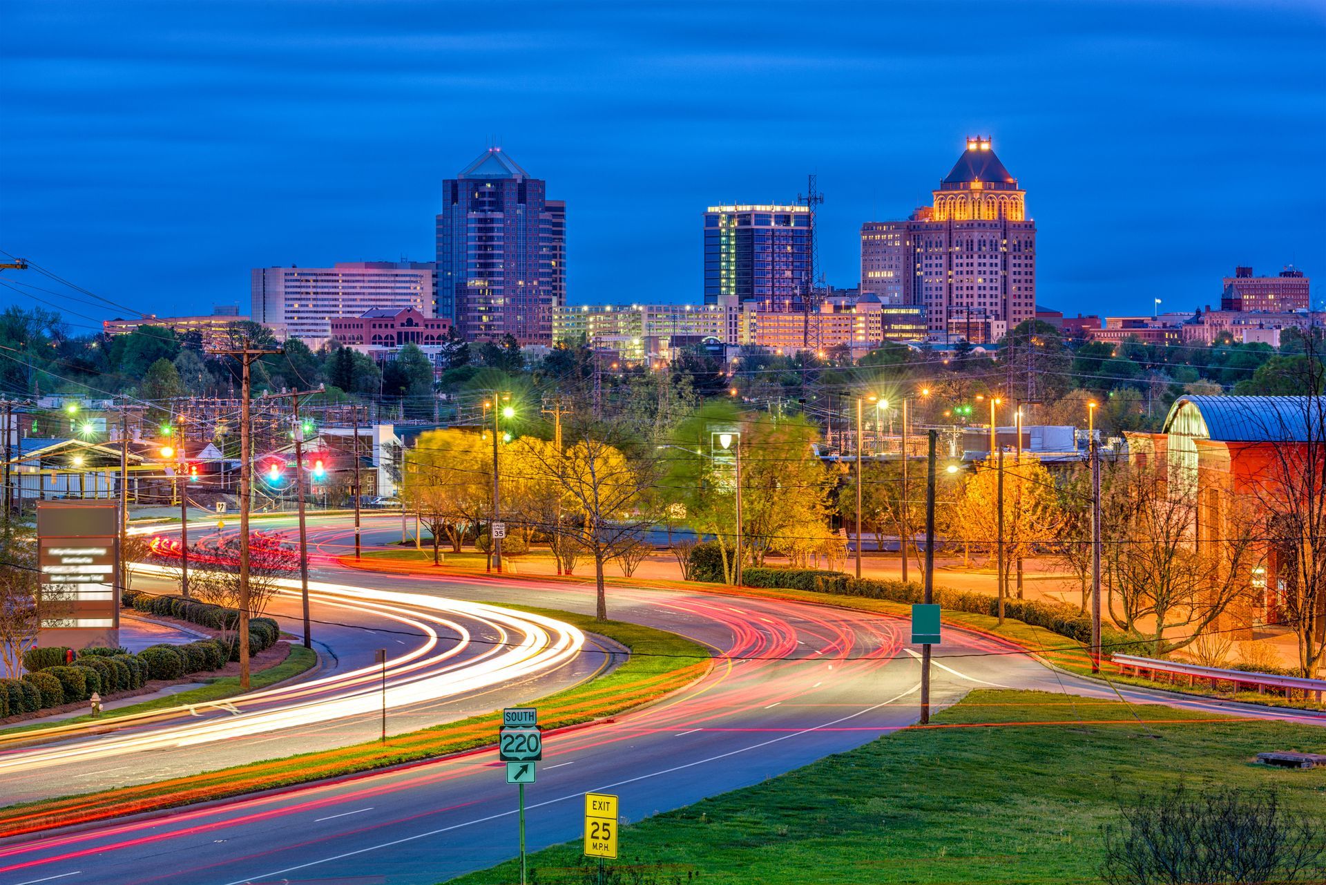 A city skyline at night with a road in the foreground.