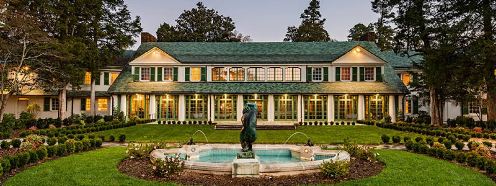 A large house with a fountain in front of it