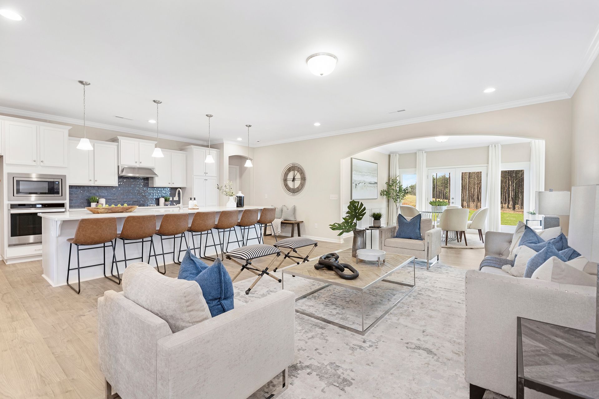 A living room filled with furniture and a kitchen in a house.