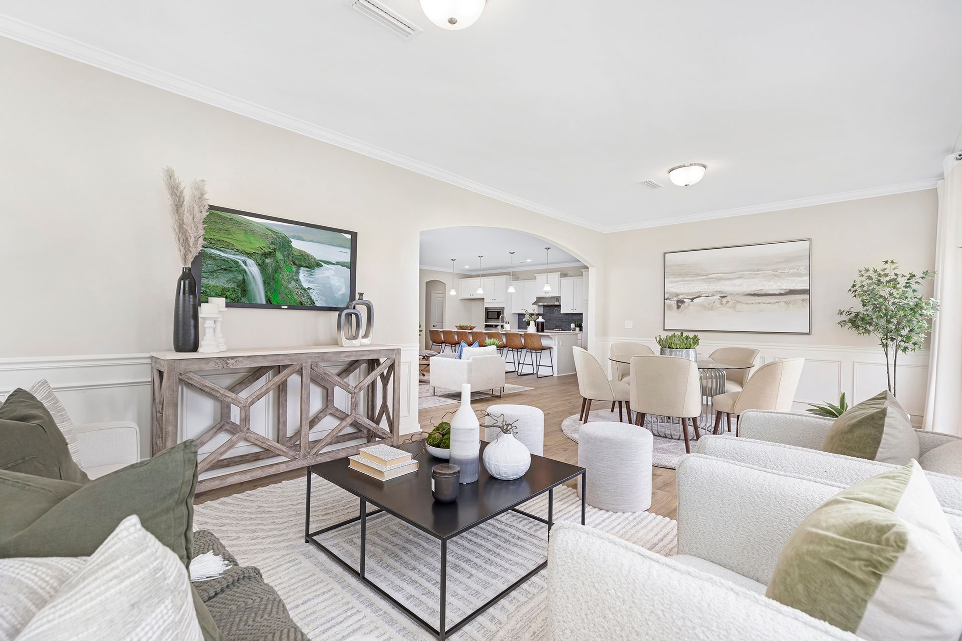 A living room with a couch , chairs , coffee table and television.