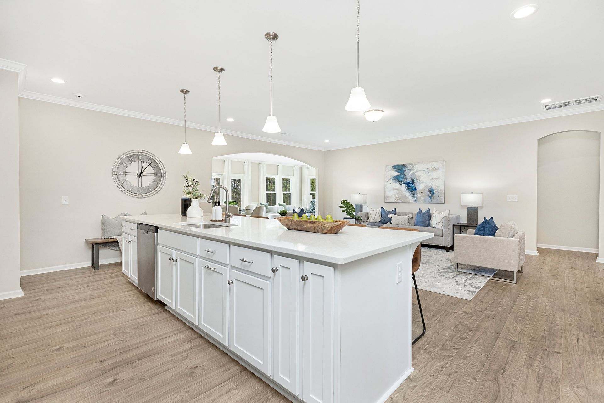 A kitchen with white cabinets and a large island in the middle of the room.