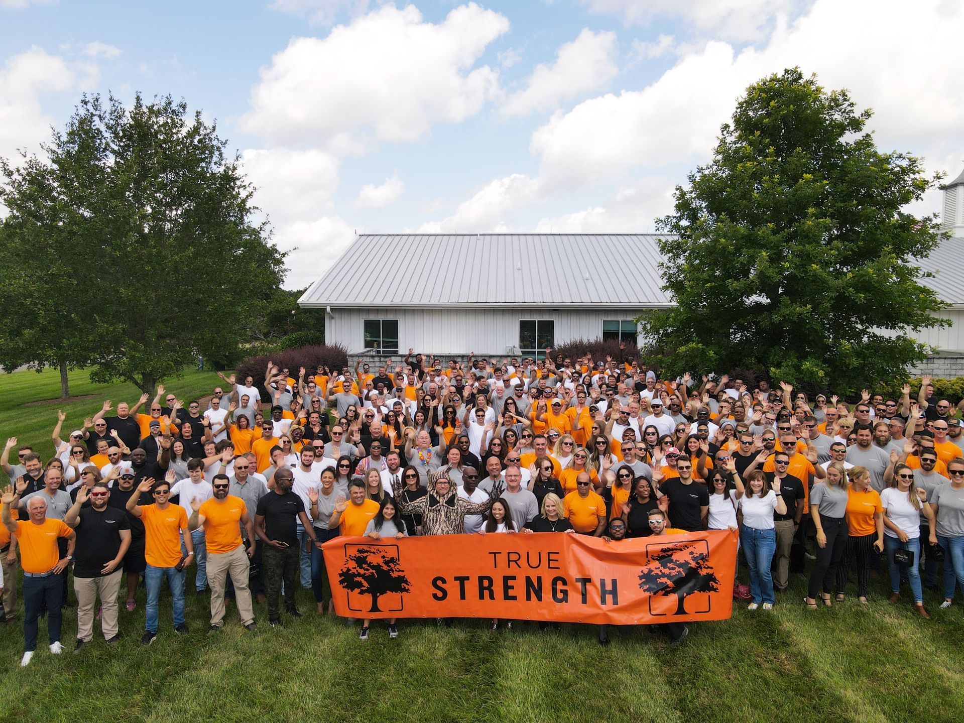 A large group of people holding an orange banner that says true strength