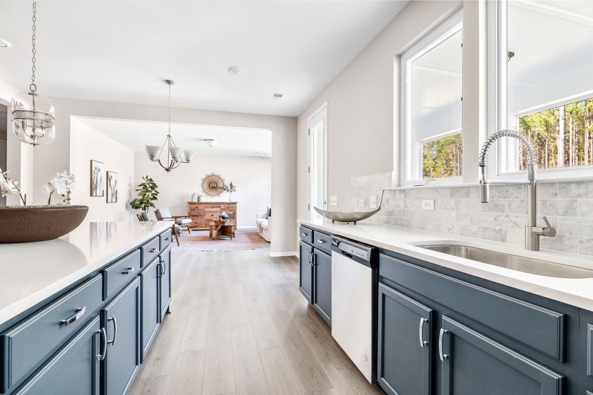 A kitchen with blue cabinets , a sink , and a dishwasher.