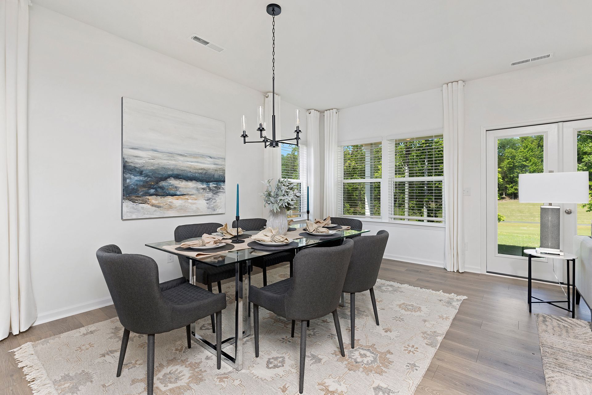 A dining room with a table and chairs and a chandelier.