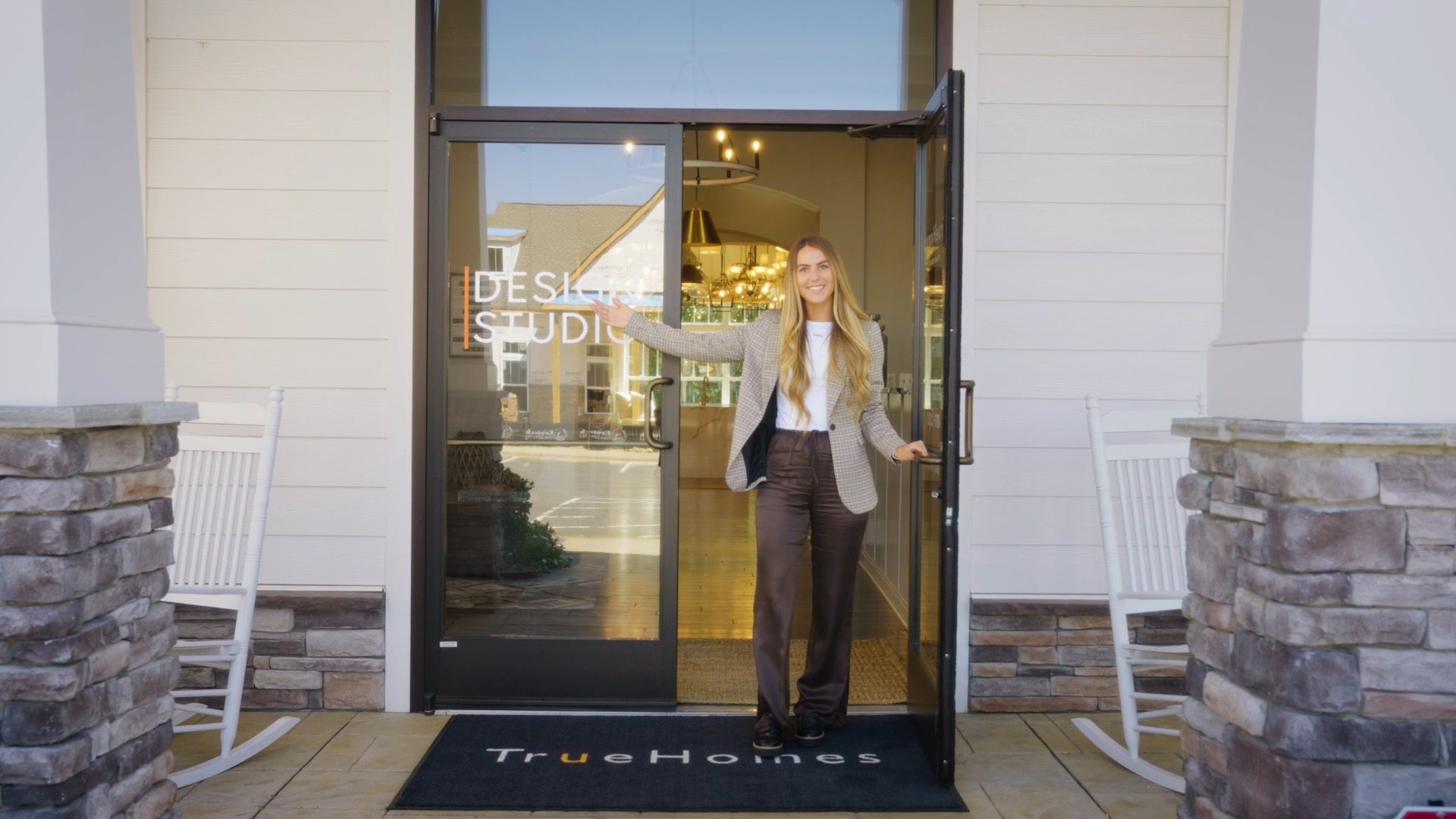 A woman is standing in the doorway of a building.