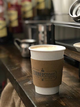A cup of coffee is sitting on a wooden table.