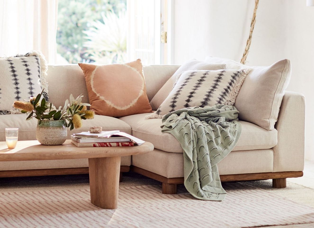A living room with a sectional couch and a coffee table.