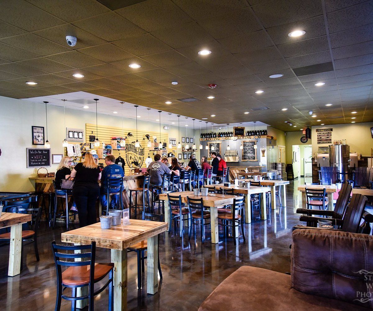 A restaurant filled with tables and chairs and a bar.