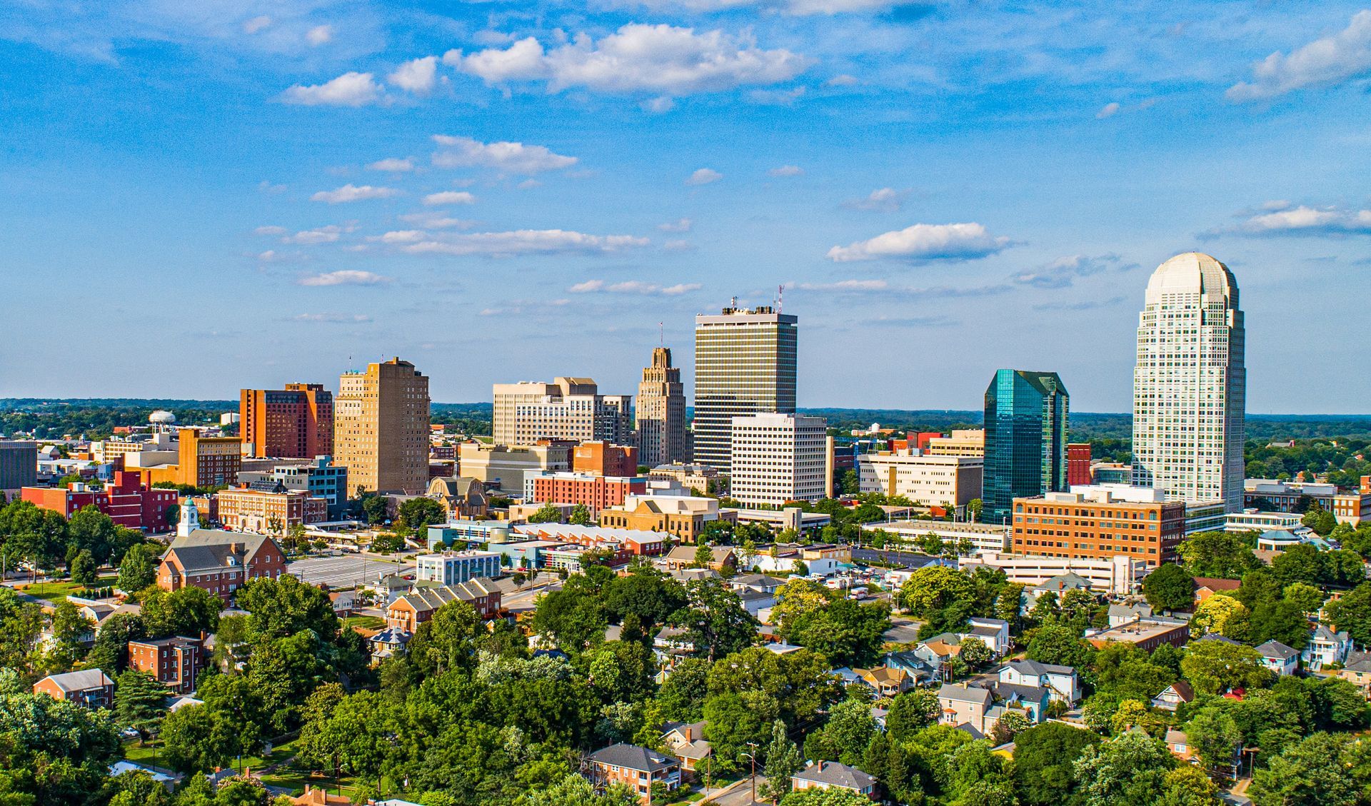 An aerial view of a city with lots of buildings and trees.