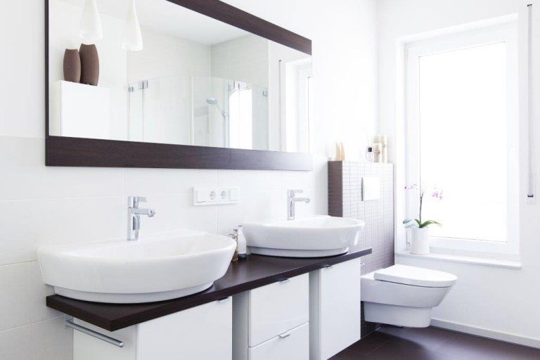 vista angolare di una bagno moderno con lavabi, specchio e bide