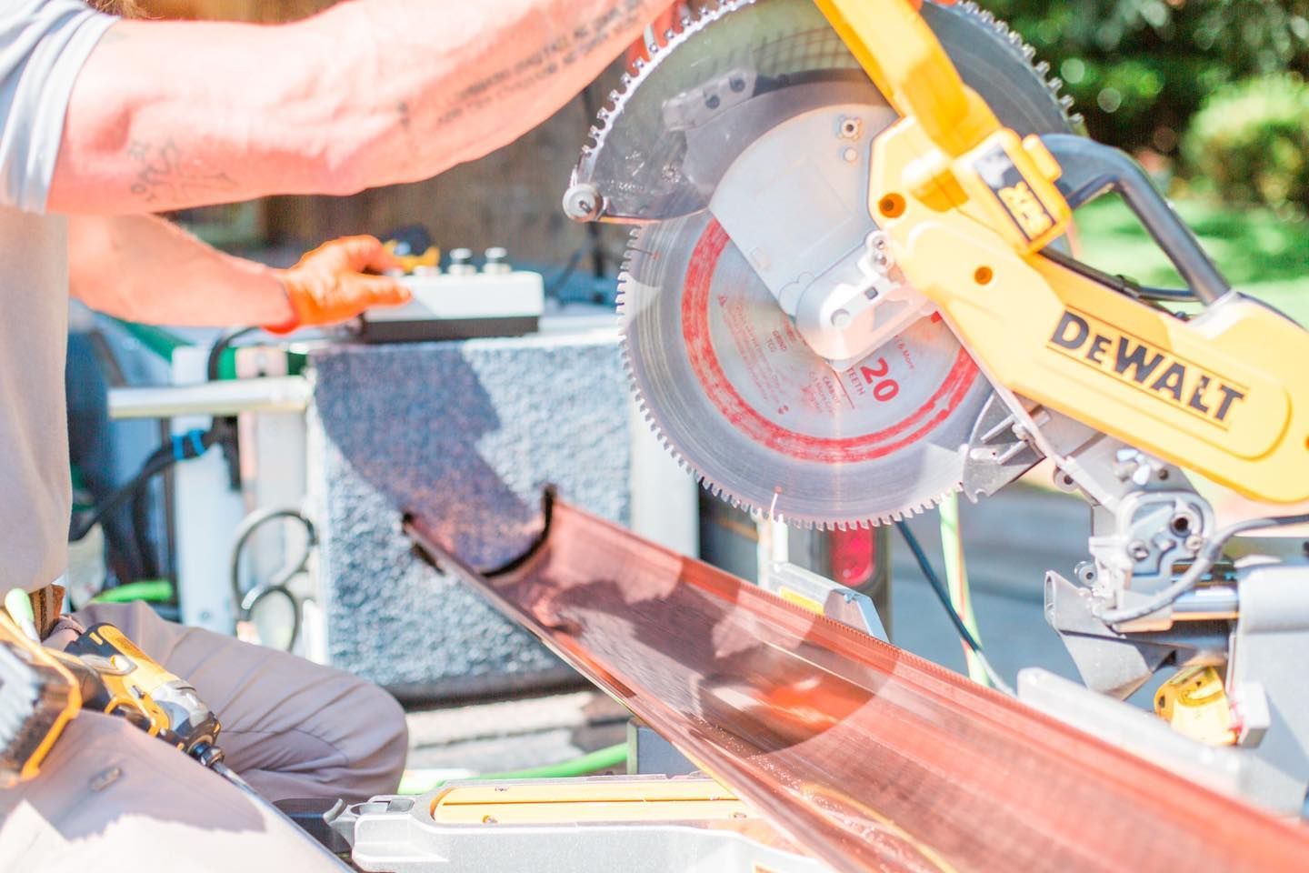 A man is cutting a piece of metal with a circular saw.