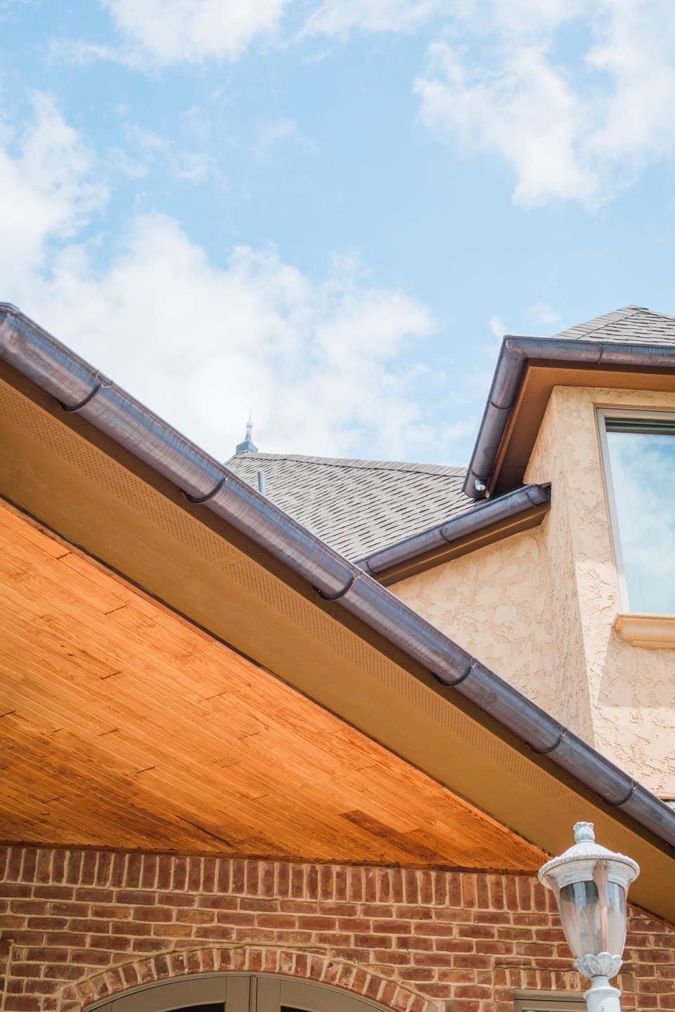 The roof of a brick house with a wooden roof and gutters.