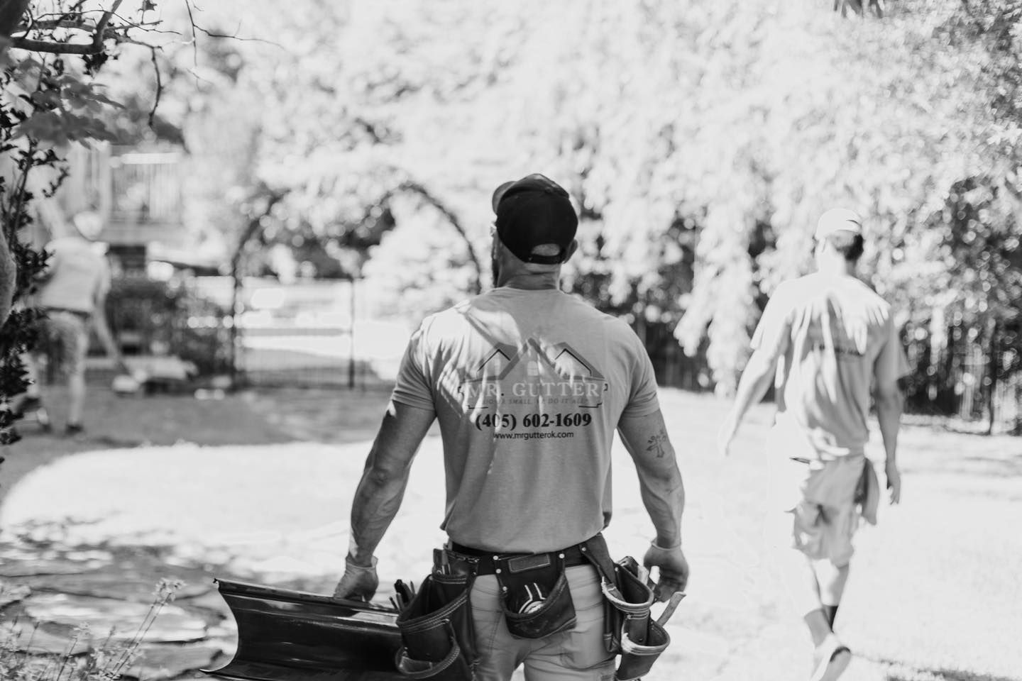 A black and white photo of a man walking down a street.