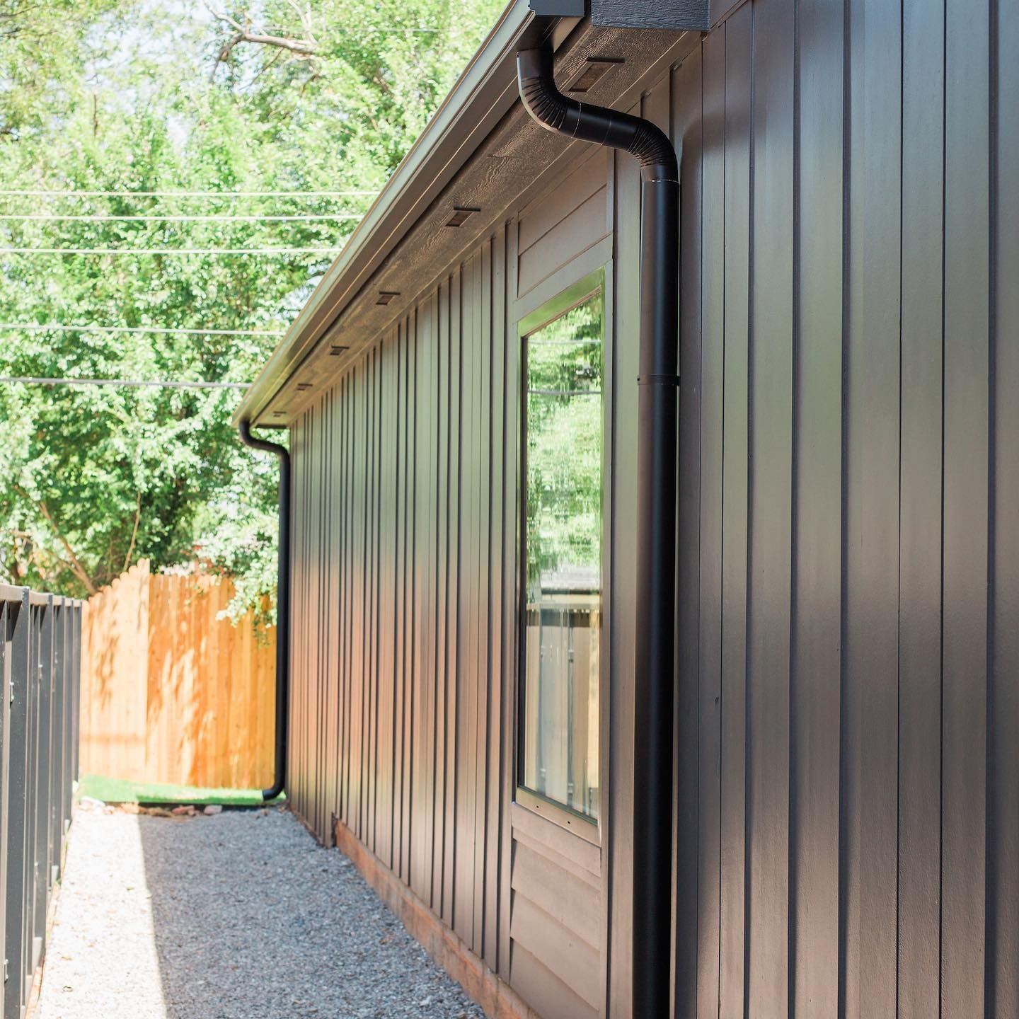 The side of a house with a gutter and a window.