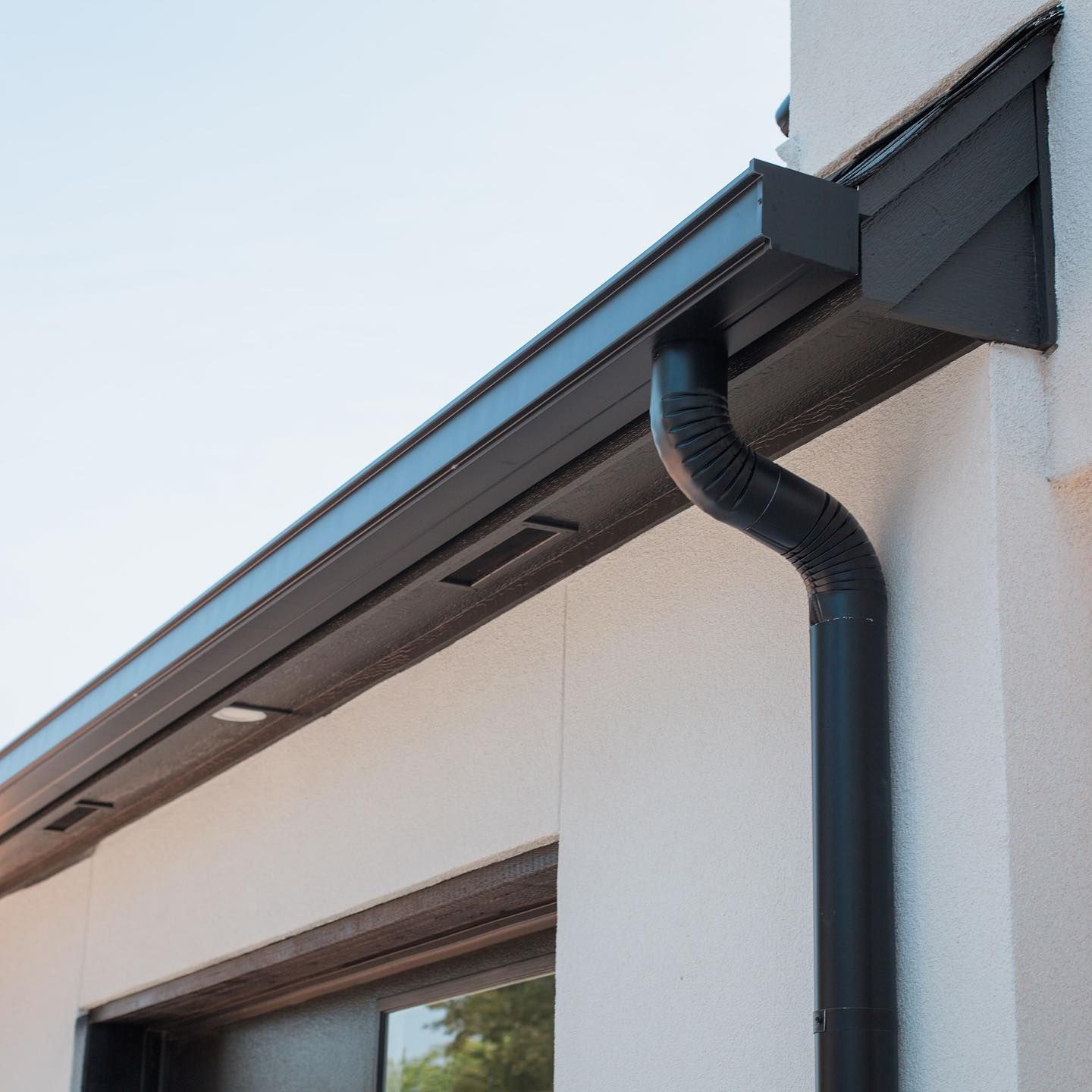 A black gutter on the side of a building