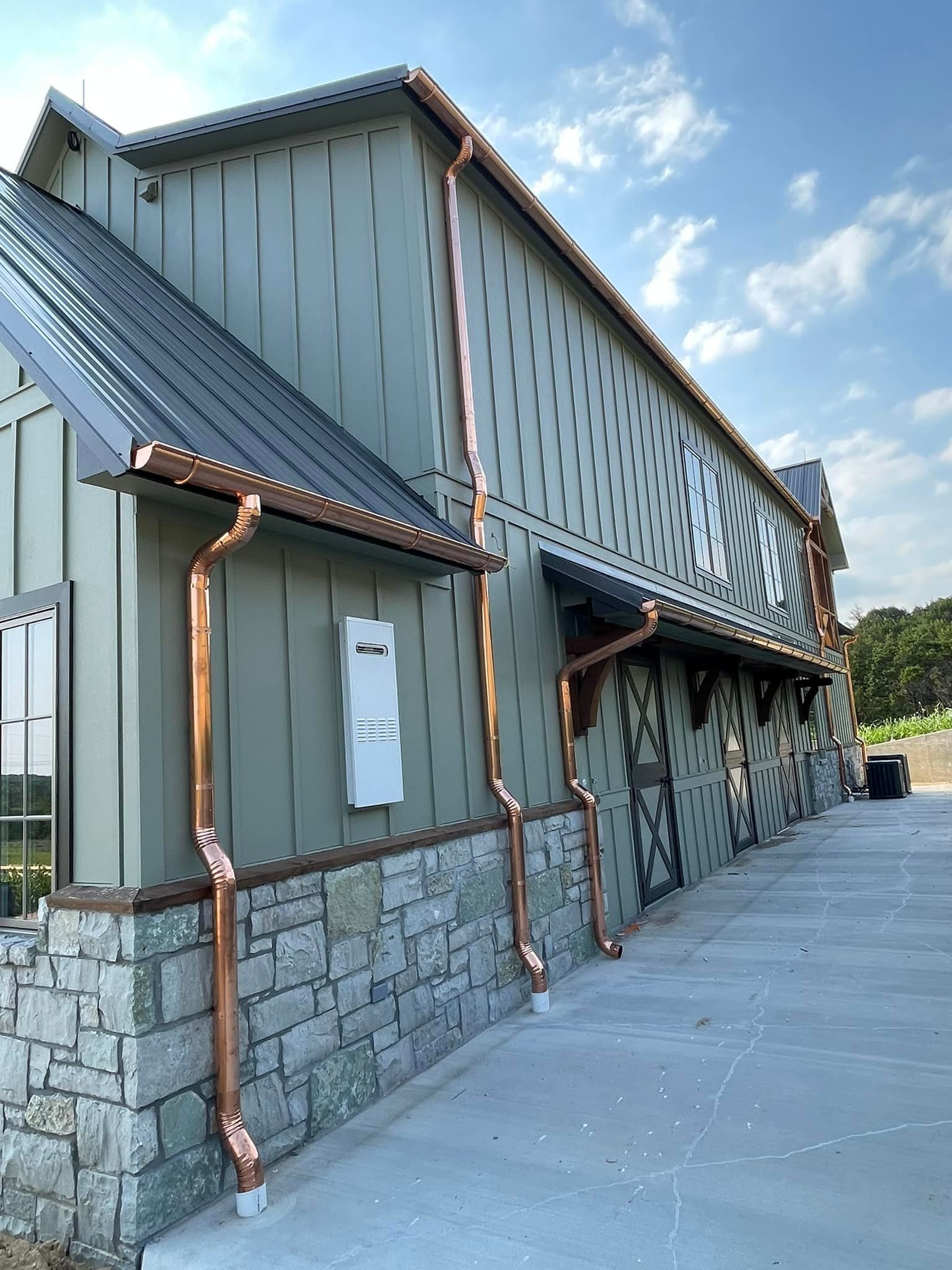 A large building with copper gutters on the side of it.