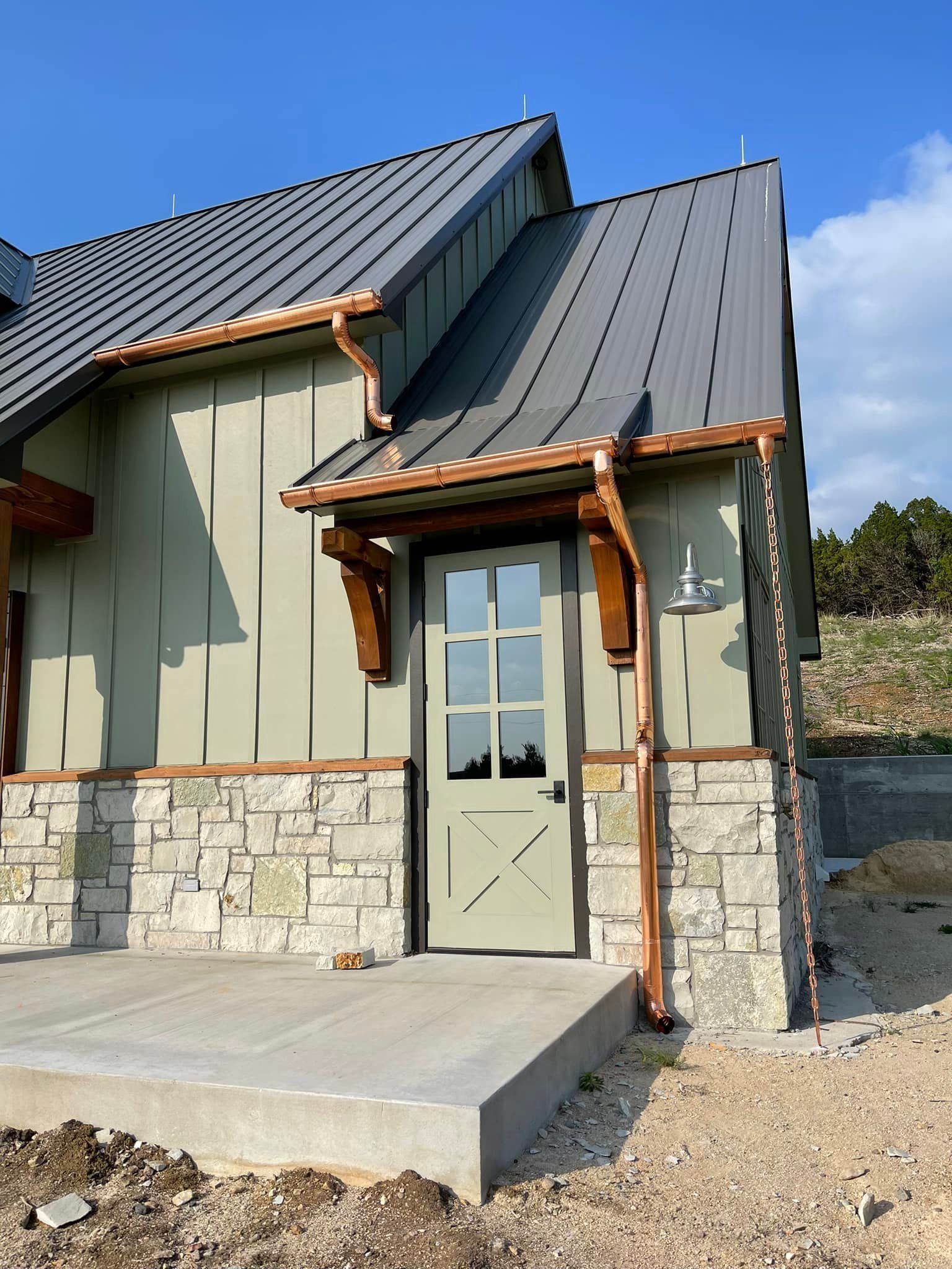 A small house with a gray roof and a green door
