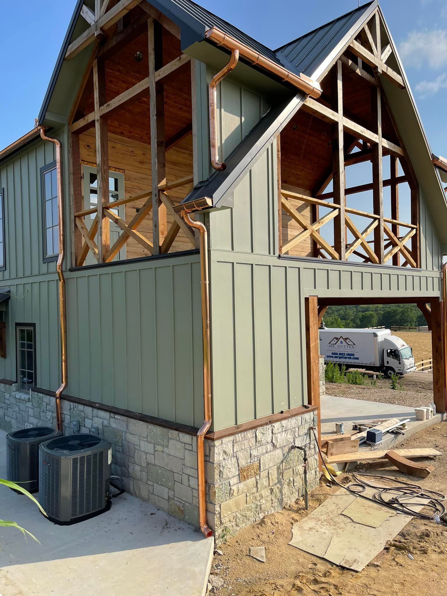 A house that is being built with copper pipes on the side of it.