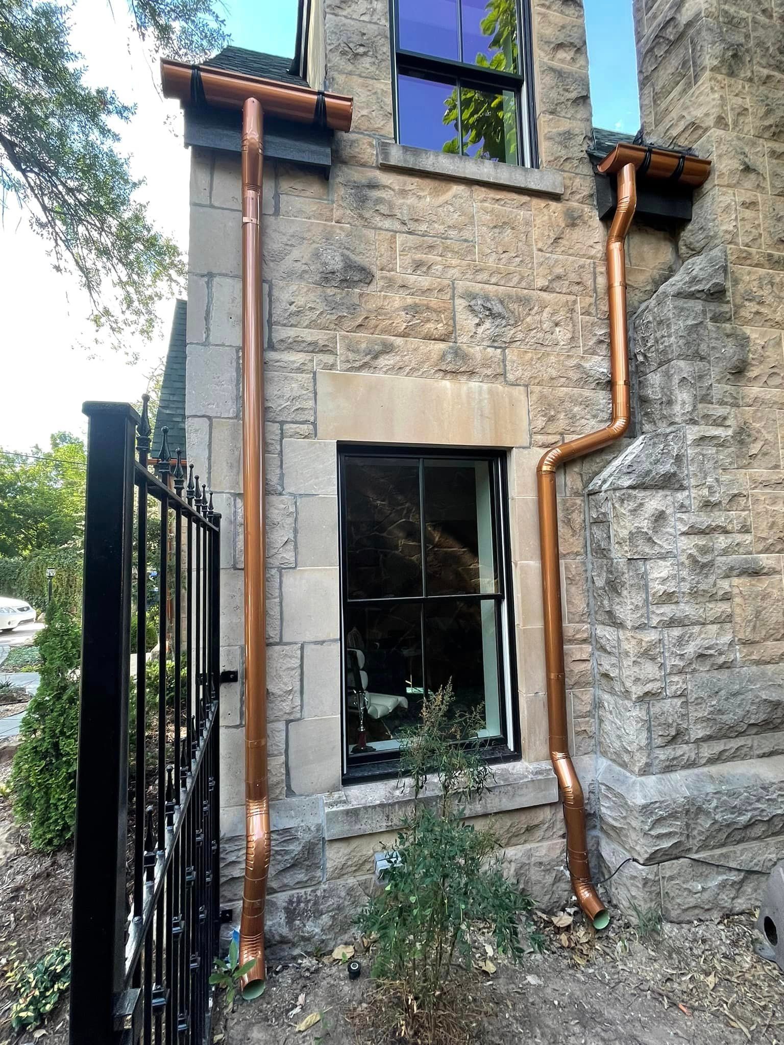 A brick building with copper gutters and a window.