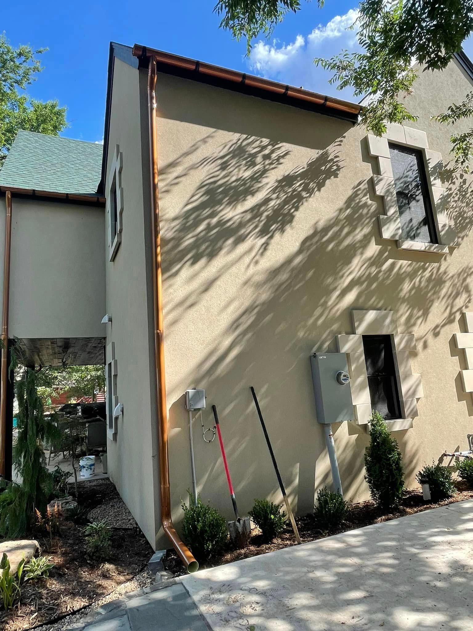 A house with a copper gutter on the side of it.