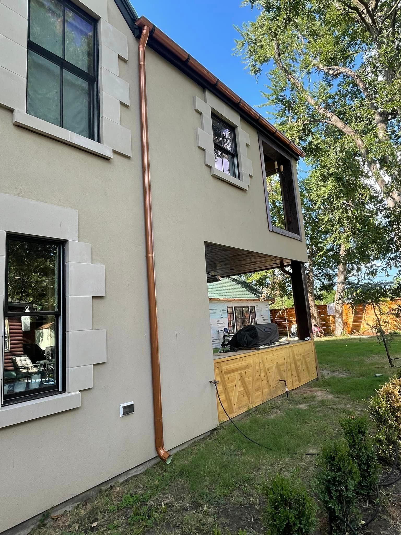 A house with a copper gutter on the side of it.