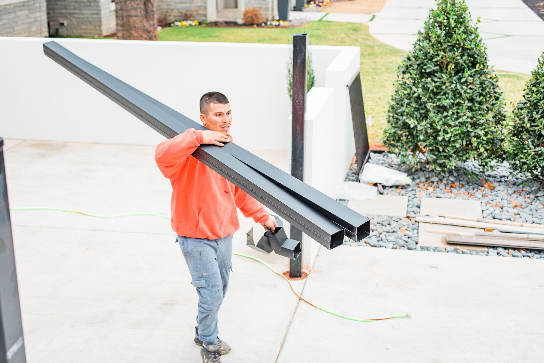 A man is carrying a large piece of metal in his hands.
