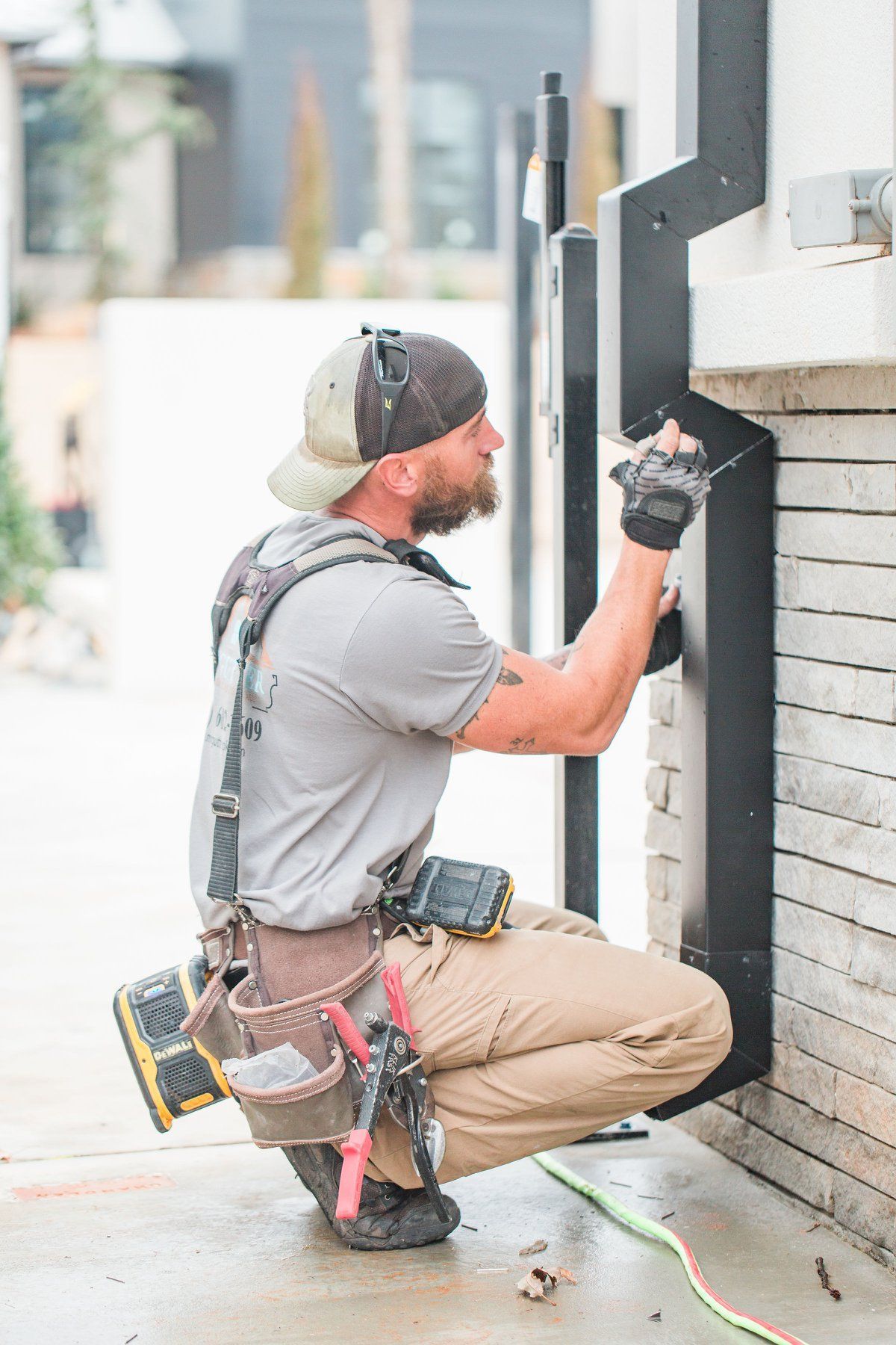 A man is kneeling down and working on a brick wall.