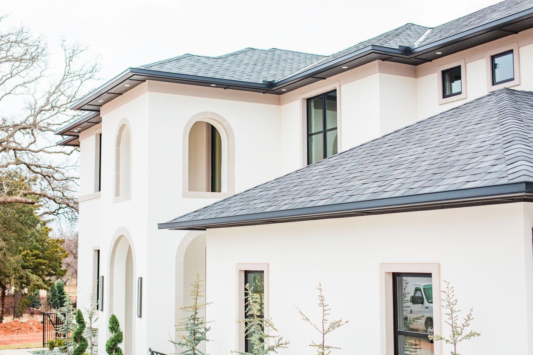 A large white house with a gray roof and black windows.