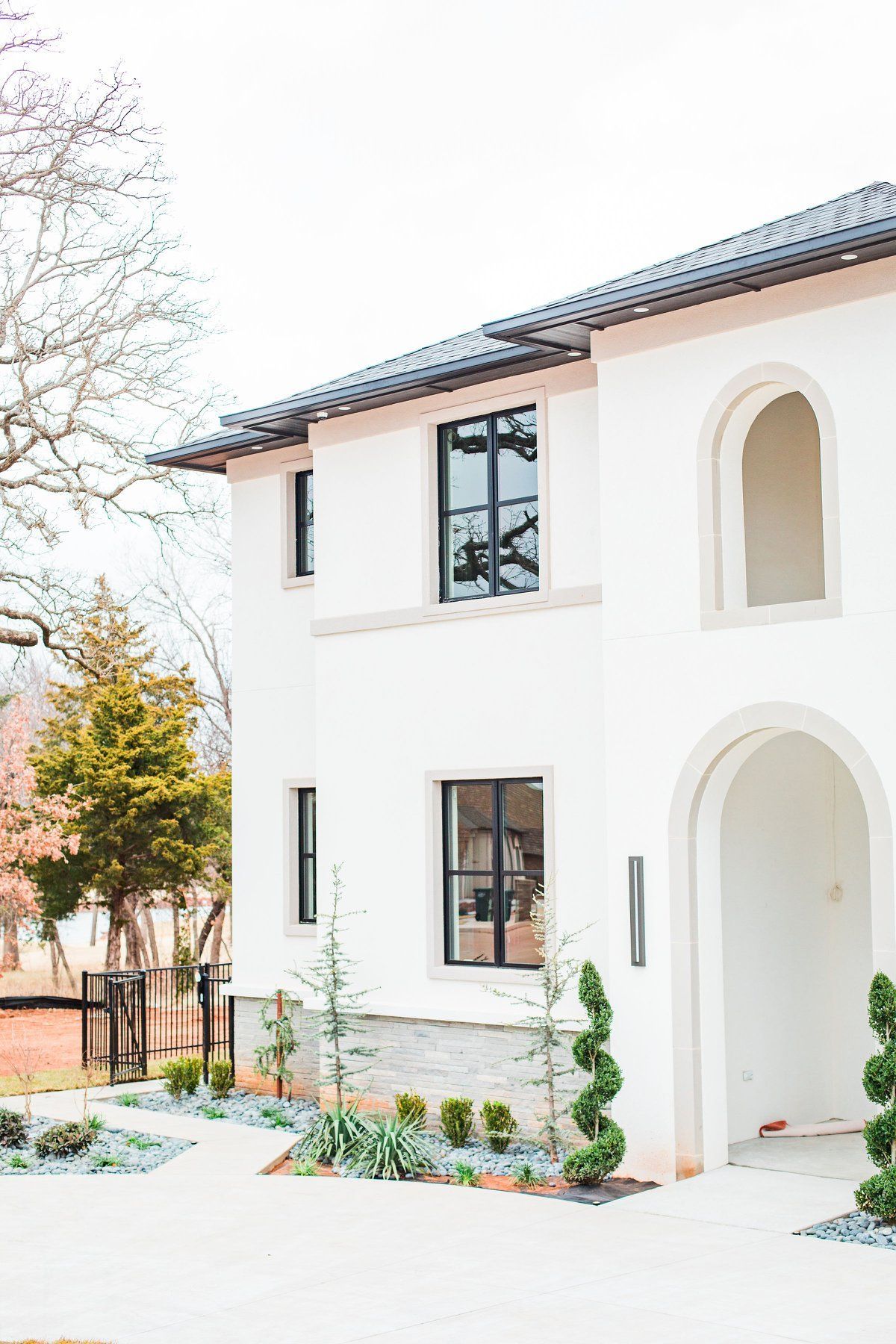 A white house with black windows and a black roof.