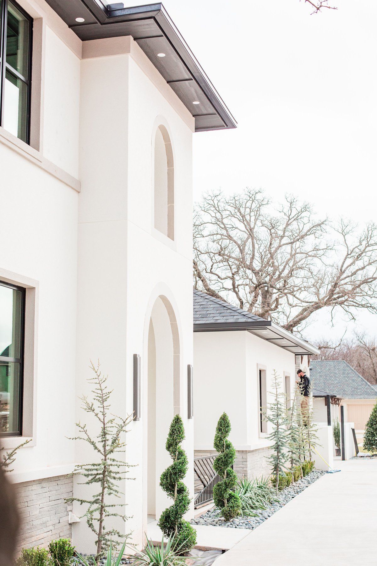 A white house with a lot of windows and trees in front of it.