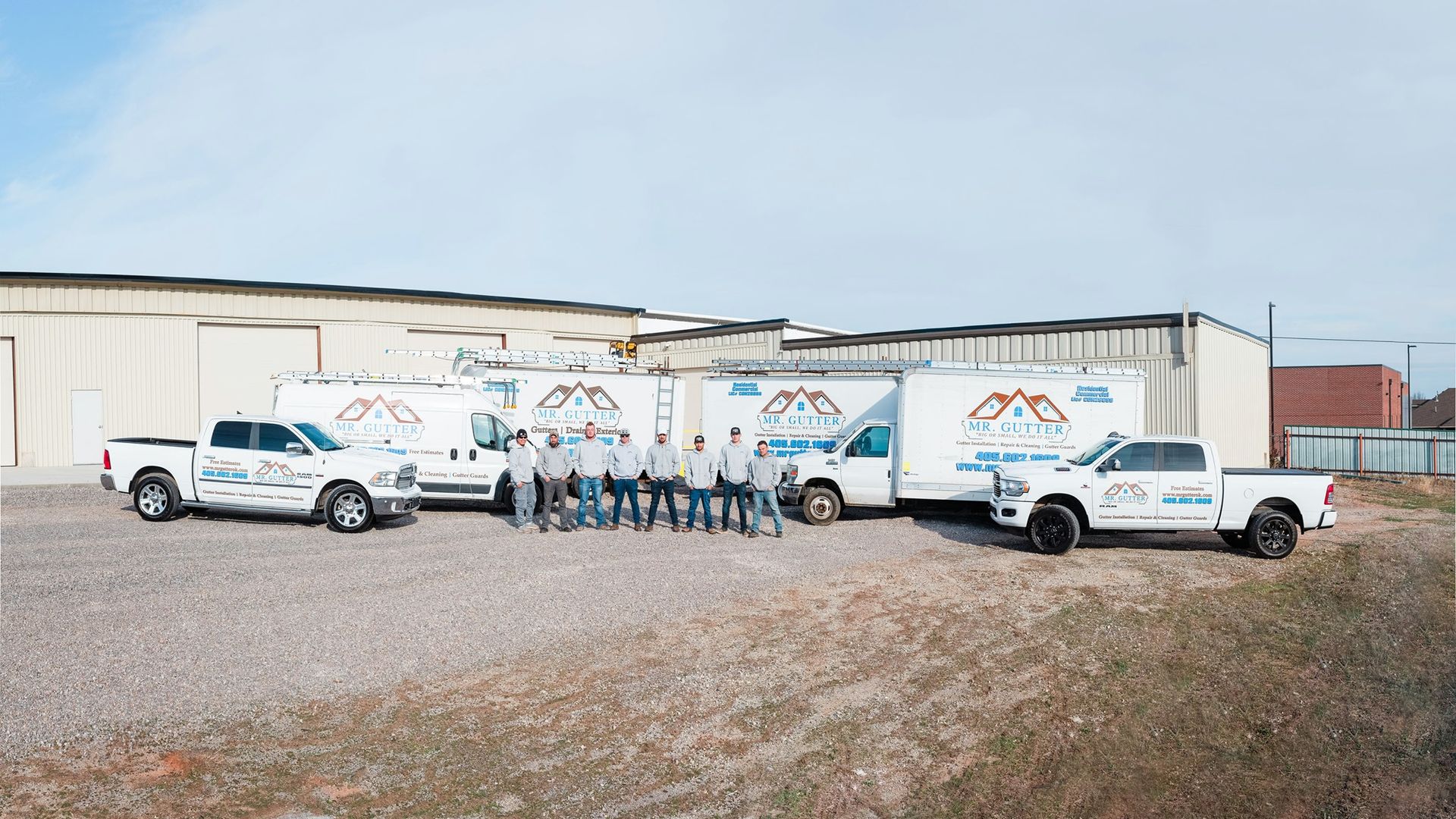A group of people standing in front of a row of trucks.