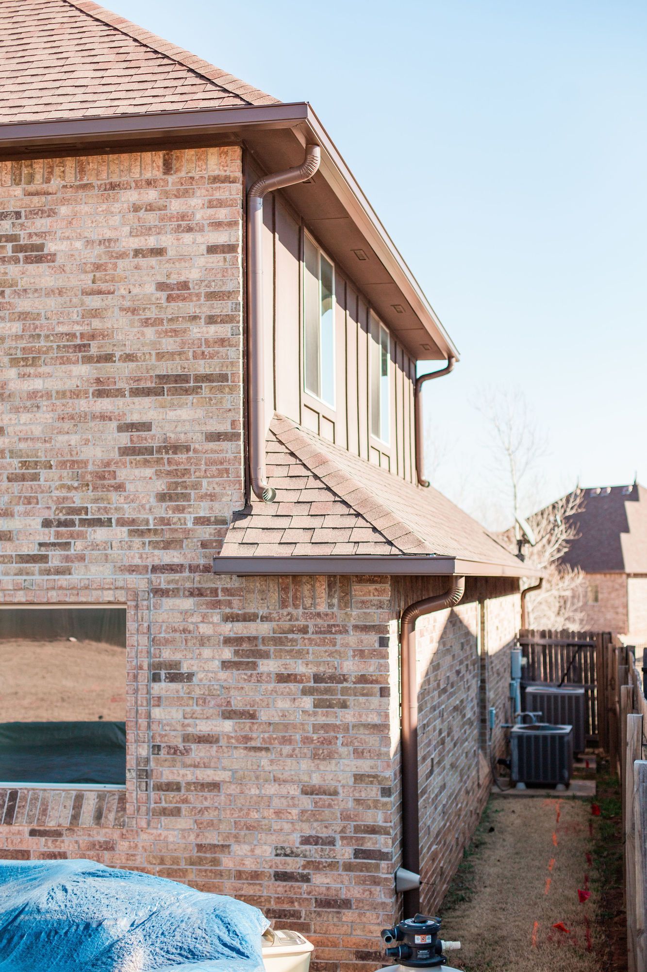 A brick house with a gutter on the side of it.