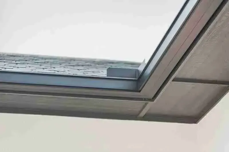 A close up of a window with a roof in the background.