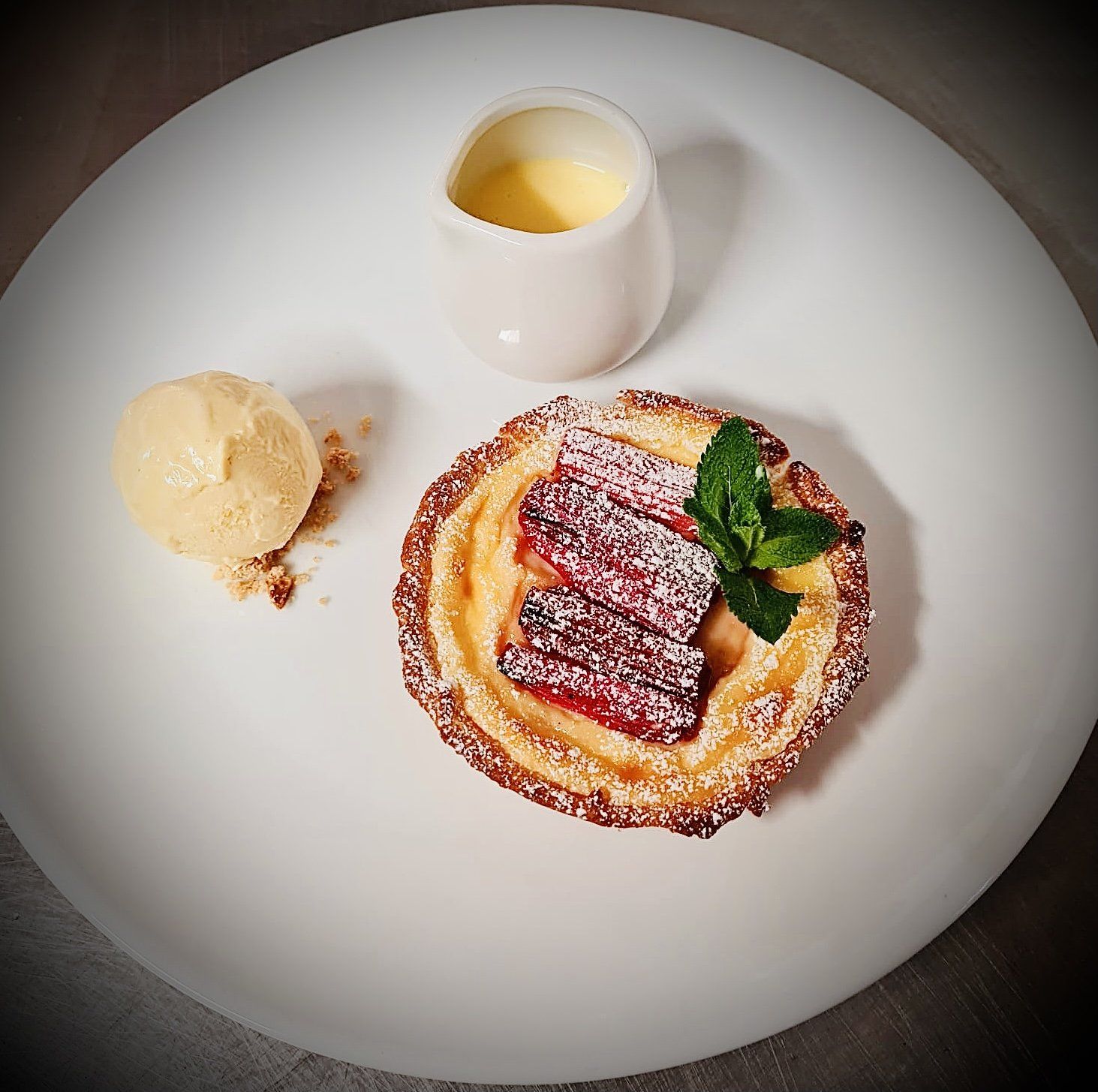 A white plate topped with a dessert and ice cream