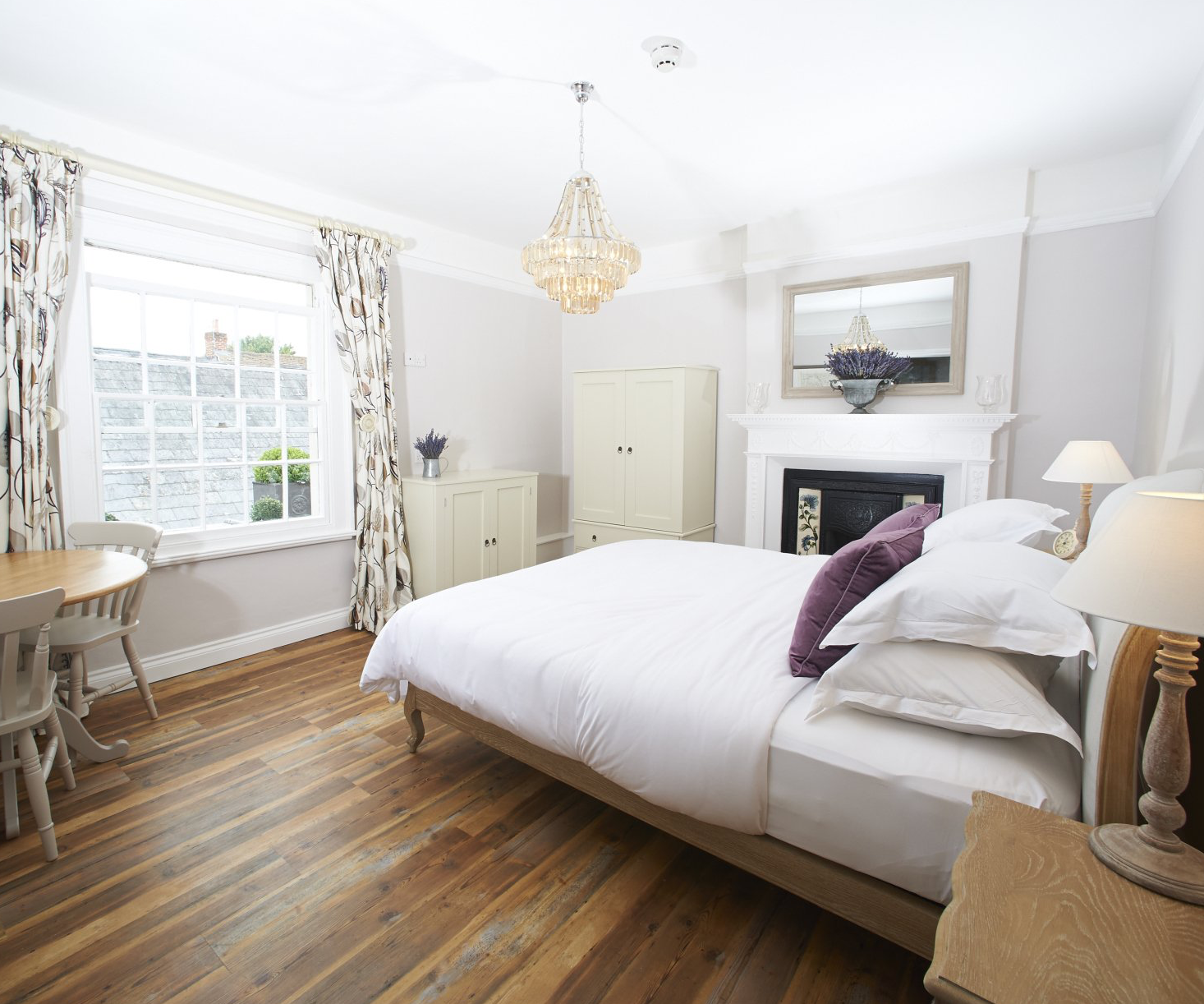 A bedroom with a large bed and a fireplace